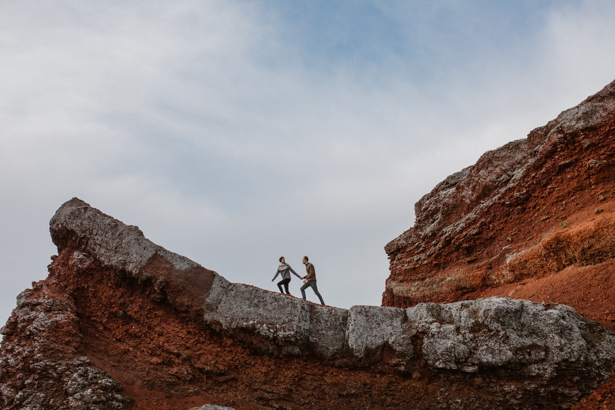 Iceland — Halldora & Hobie on red volcanic rock.